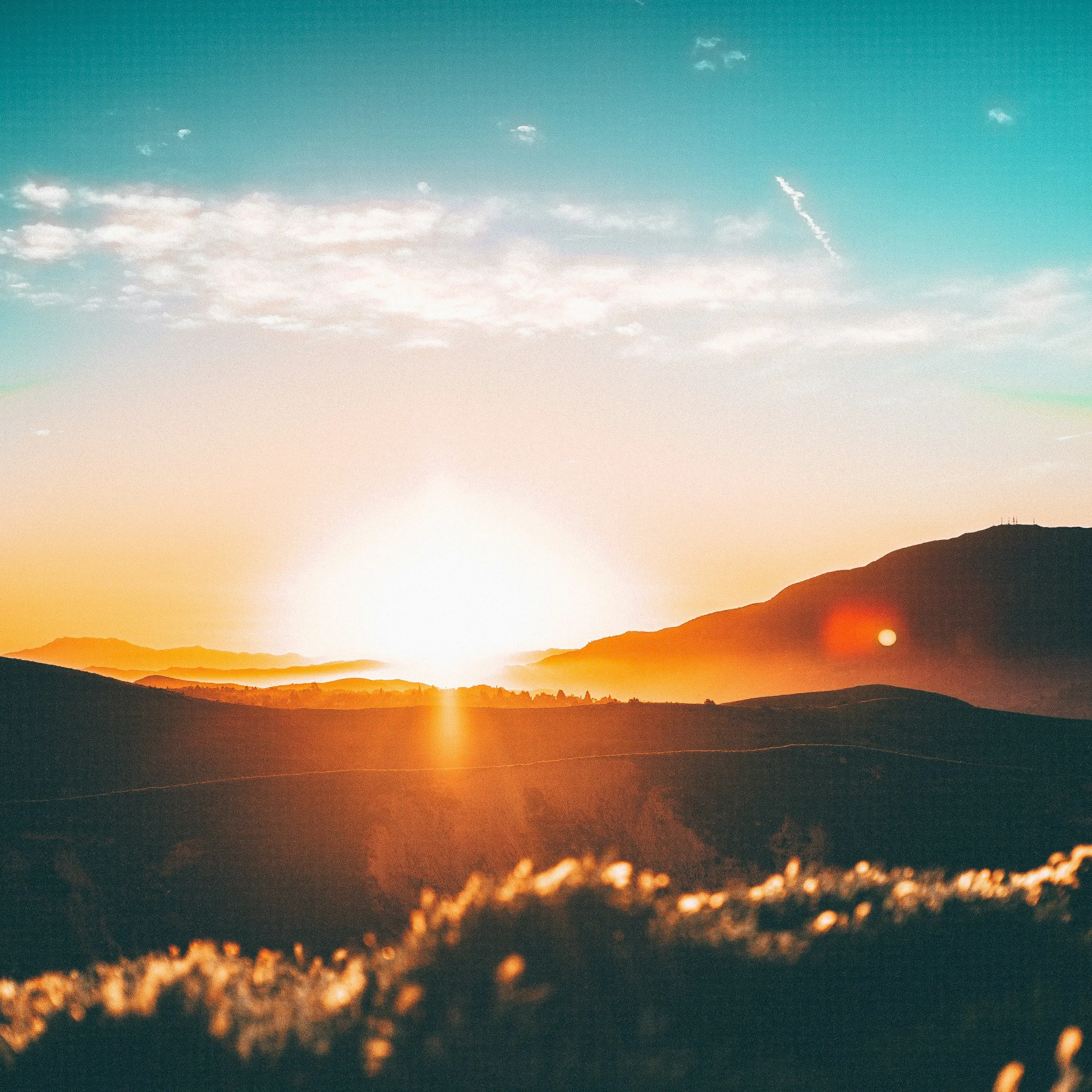 Layered hills at dawn, mist settling in the valleys, warm light on the ridges