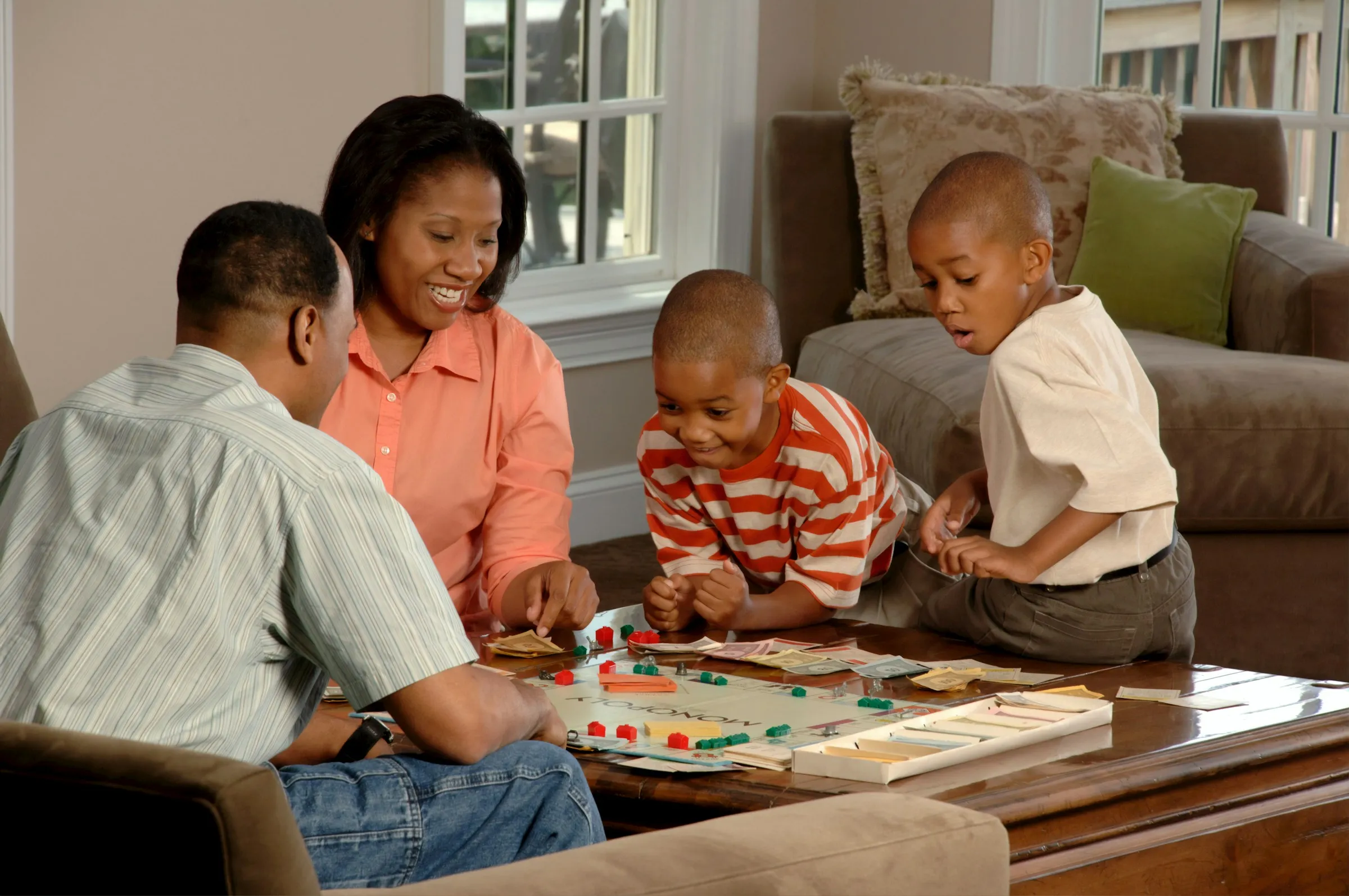 A family sitting together in a living room playing a board game